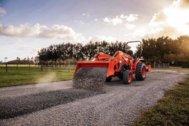 Tractor unloading gravel onto drivway