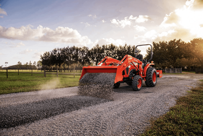 Tractor unloading gravel onto drivway
